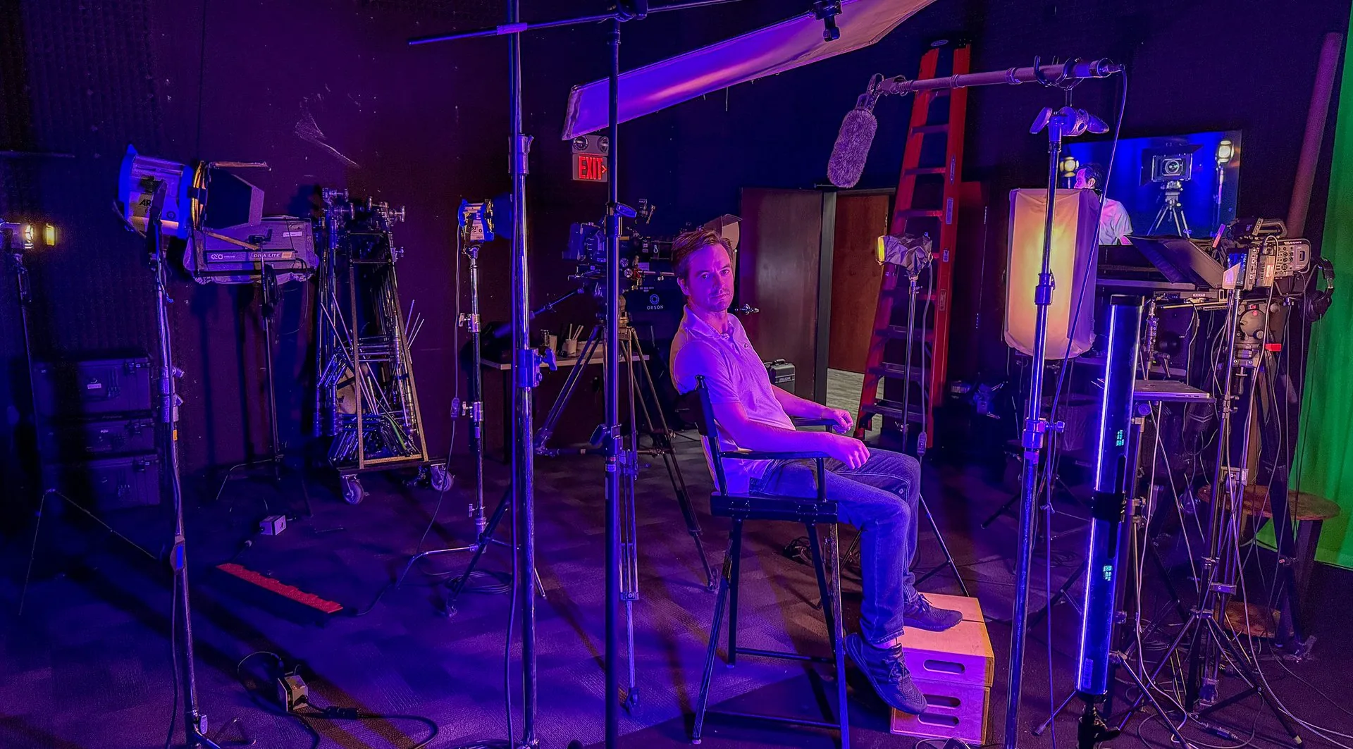 Matt Dunham on a film set, with lights and C-stands behind him